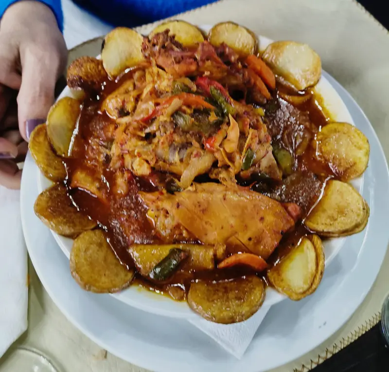 Pollo al disco con papas, uno de los platos de la casa